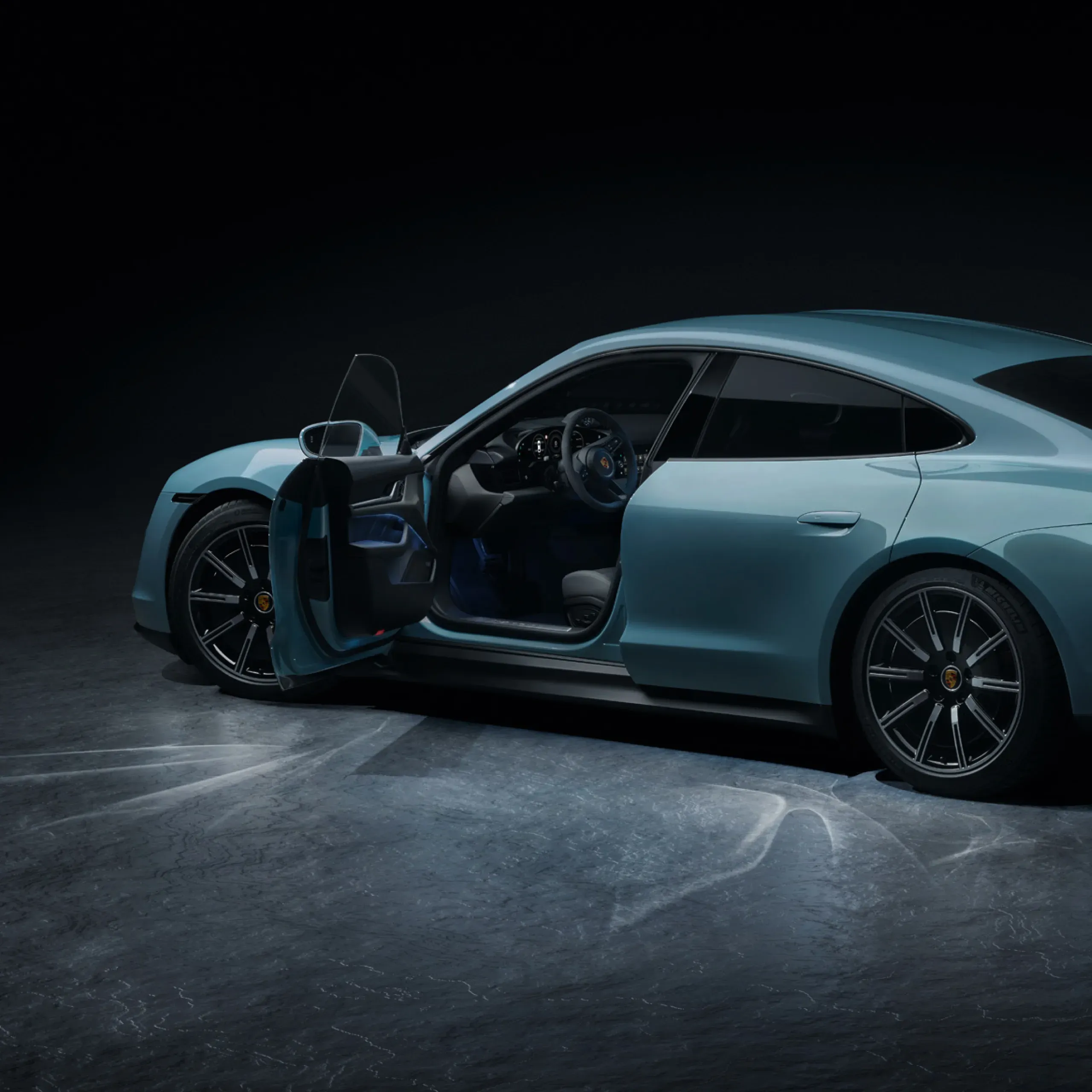 Side view of a blue sports car with driver and passenger doors open.